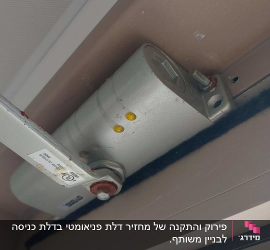 תקריב של מחזיר דלת הידראולי דולף שמן בחלק העליון של המשקוף
